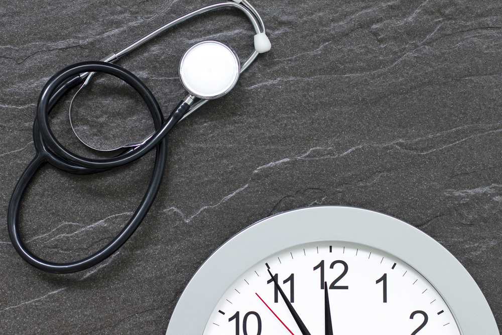 Stethoscope and a clock laying next to each other.